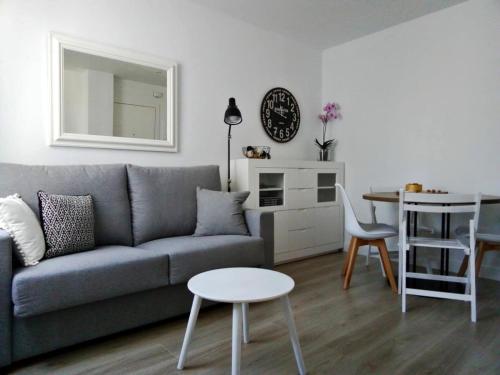 a living room with a gray couch and a table at Morriña in Ourense