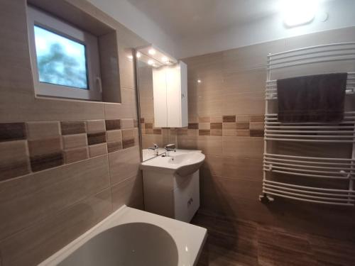 a bathroom with a sink and a toilet and a window at Szent Erzsébet Apartmanház in Kecskemét