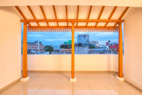 a room with a view of a city from a window at La Maison Charu in Puducherry