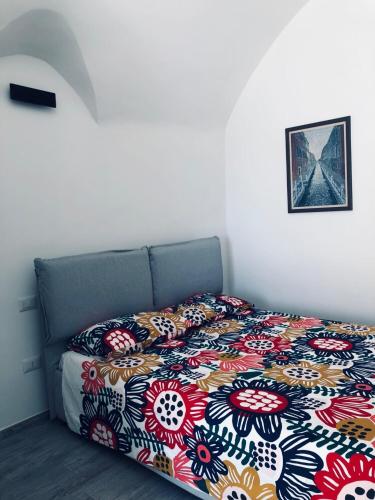 a bedroom with a bed with a colorful blanket at Fico d’India apartments in Monte SantʼAngelo