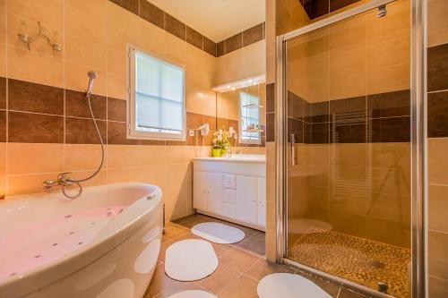 La salle de bains est pourvue d'une baignoire, d'une douche et d'un lavabo. dans l'établissement Villa Salena, à Sainte-Lheurine