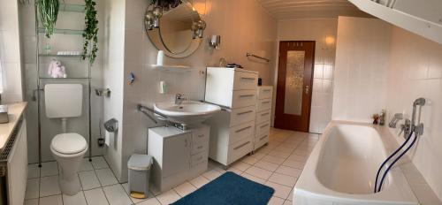 W łazience znajduje się umywalka, toaleta i wanna. w obiekcie Ferienwohnung Schmetterling w mieście Fritzlar