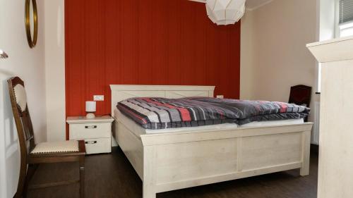 een slaapkamer met een bed en een rode muur bij Ferienhaus Alte Schule in Volkesfeld