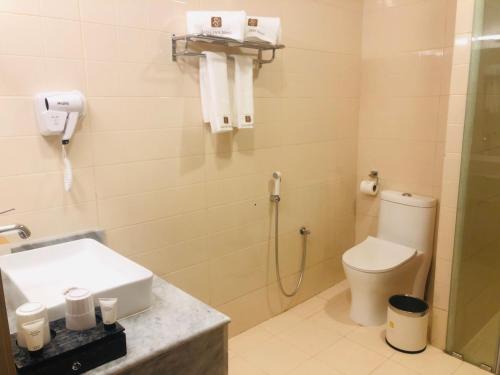 a bathroom with a shower and a toilet and a sink at Season Inn Hotel in Barka