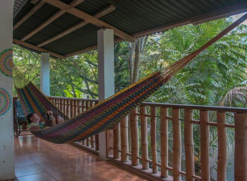a couple chilling in a hammock on a porch at Viñas Hotel in Lanquín