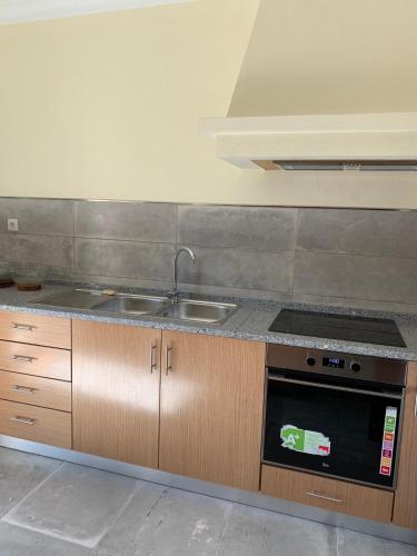 a kitchen with a sink and a stove at Casa da Fonte in Seia