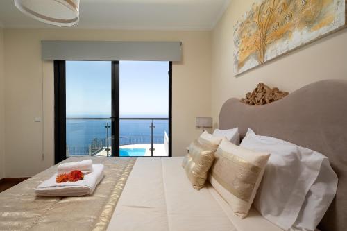 una camera con letto e vista sull'oceano di CASA DO MASSAPEZ, HOUSE B - LUXURY, PRIVATE POOL ad Arco da Calheta