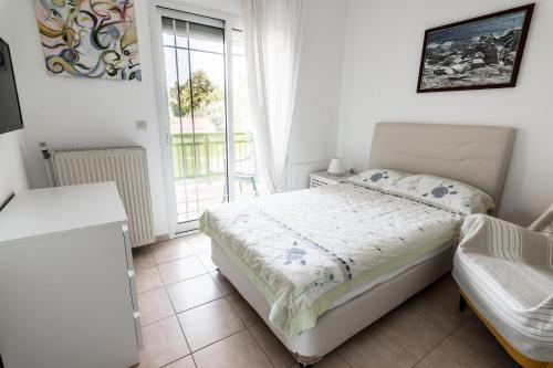 a small bedroom with a bed and a window at Anthos Apartments in Limenas