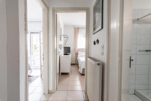 a hallway with a bathroom with a shower and a bedroom at Anthos Apartments in Limenas