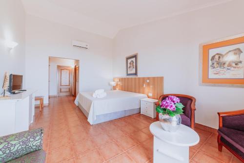 une chambre d'hôtel avec un lit et un canapé dans l'établissement Villa Amore Accommodation, à Paul do Mar