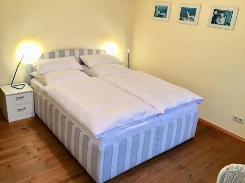 uma grande cama branca num quarto com 2 candeeiros em Lichtdurchflutetes Apartment Prenzlauerberg em Berlim
