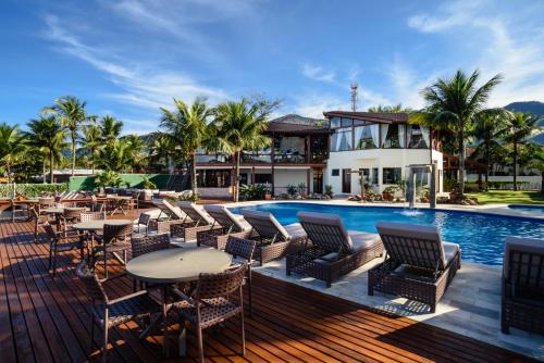 ein Bild eines Resorts mit einem Pool, Tischen und Stühlen in der Unterkunft Coconut's Maresias Hotel in Maresias