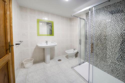 a bathroom with a shower and a sink and a toilet at HOTELBARCELONA in Entrimo