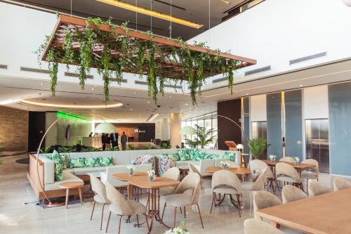 a restaurant with tables and chairs in a building at Hotel Pullman City Center Rosario in Rosario
