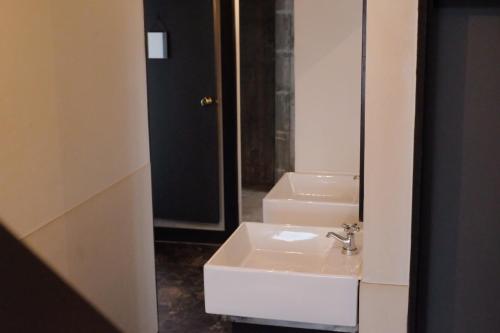 een badkamer met een wastafel en een spiegel bij Beppu hostel&cafe ourschestra - Vacation STAY 45098 in Beppu