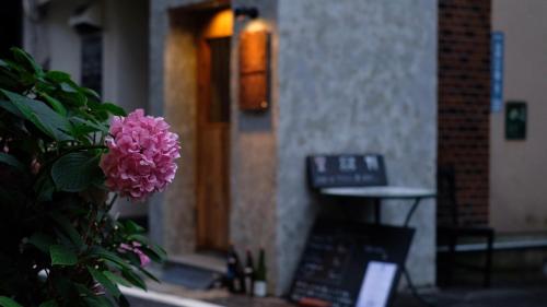 a pink flower sitting in front of a door at Beppu hostel&cafe ourschestra - Vacation STAY 45859 in Beppu