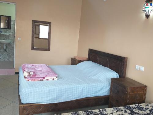 a bedroom with a bed with a pink blanket on it at Oasis de Tiout in Tiout