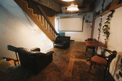Beppu hostel&cafe ourschestra - Vacation STAY 45098 في بيبو: غرفة بها كرسيين وشاشة في الغرفة