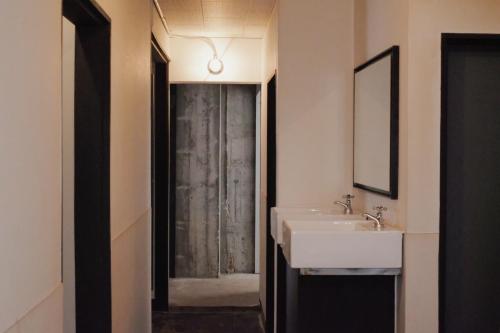 La salle de bains est pourvue d'un lavabo et d'une douche. dans l'établissement Beppu hostel&cafe ourschestra -Vacation STAY 45089, à Beppu