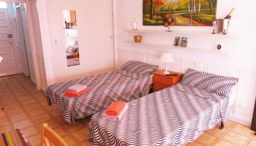 a room with two beds and a table with a lamp at Studio in perfect location in Playa de las Americas