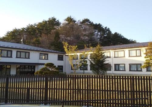 un grand bâtiment blanc avec une clôture devant lui dans l'établissement Higashimatsushima - Hotel / Vacation STAY 43089, à Higashimatsushima