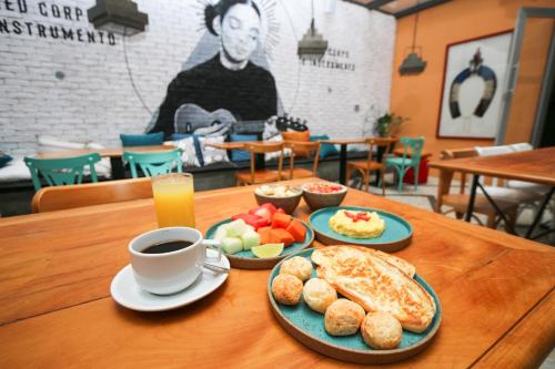 a table with two plates of food and a cup of coffee at Socialtel Lapa Rio de Janeiro in Rio de Janeiro