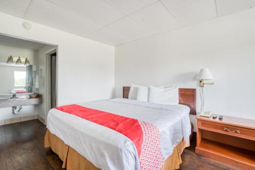 a bedroom with a bed with a red and white blanket at OYO Hotel San Antonio Lackland Air Force Base West in San Antonio