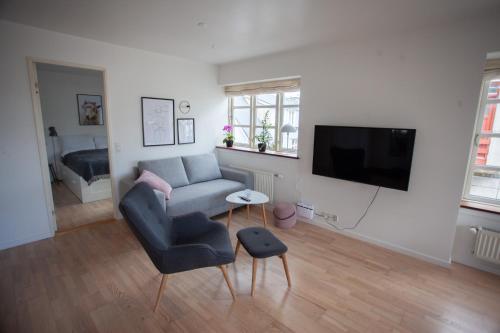 a living room with a couch and a tv at Central apartment in Tórshavn in Tórshavn