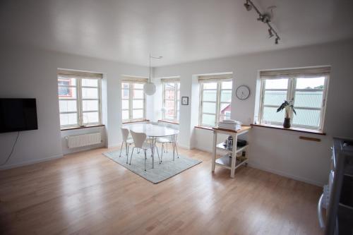 a living room with a table and chairs and windows at Central apartment in Tórshavn in Tórshavn