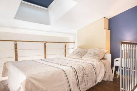 a bedroom with a bed with white sheets and pillows at beau meublé centre historique in Bordeaux