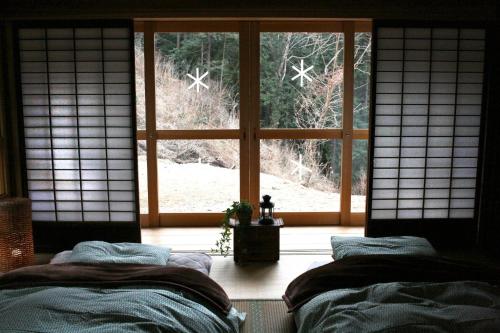 a room with two beds in front of a window at Uenohara - House / Vacation STAY 47885 in Uenohara