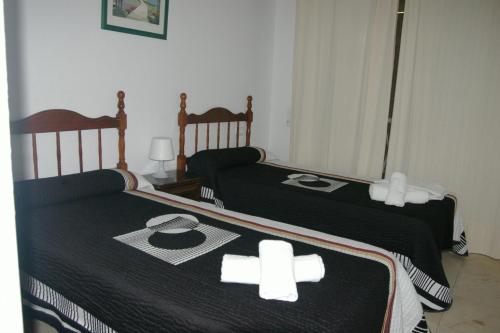 2 Betten mit Kreuzen in einem Schlafzimmer in der Unterkunft Apartamentos Carolina - Arca Rent in Benidorm