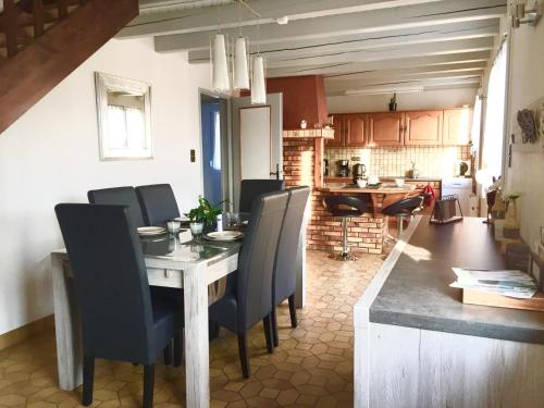 une cuisine et une salle à manger avec une table et des chaises dans l'établissement Maisonnette vue sur la montagne, à Vagney