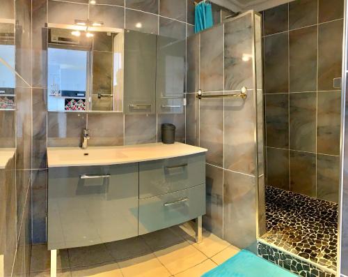 une salle de bain avec un lavabo et une douche dans l'établissement Le Zéphyr, superbe appartement à la Corniche avec parking, à Sète