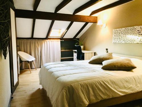 um quarto com uma cama grande com almofadas em Maisonnette vue sur la montagne em Vagney