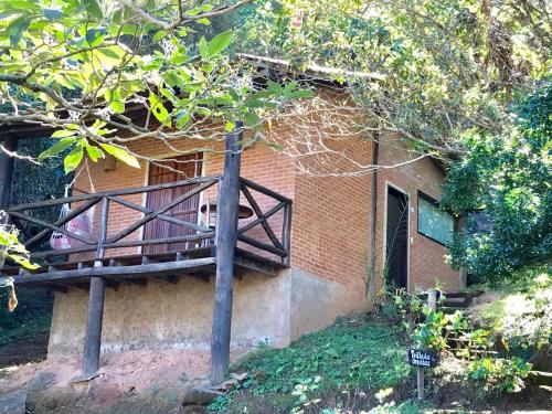 a building with a wooden deck on the side of it at Pousada Recanto da Siriema in Monte Alegre do Sul