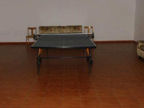 a ping pong table in a room with two chairs at El pequeño capricho in Arenas de San Pedro