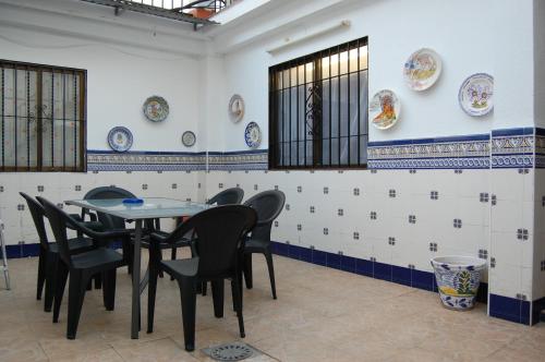 ein Esszimmer mit einem Tisch, Stühlen und Platten an der Wand in der Unterkunft Casa de David in Córdoba