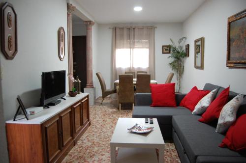 ein Wohnzimmer mit einem Sofa und einem TV in der Unterkunft Casa de David in Córdoba