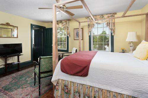 1 dormitorio con 1 cama grande y TV en Spencer House Inn, en Saint Marys