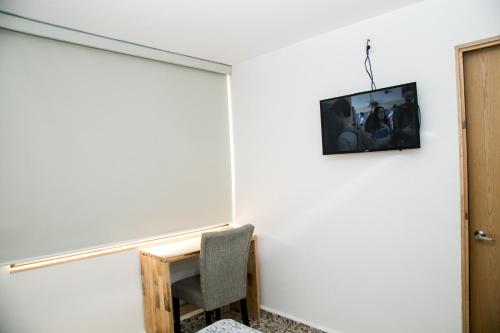 a room with a chair and a tv on the wall at Booking 500 in Monterrey