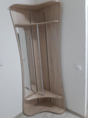 a wooden book shelf in a corner of a room at Смарт квартира сдана 2019 in Odesa
