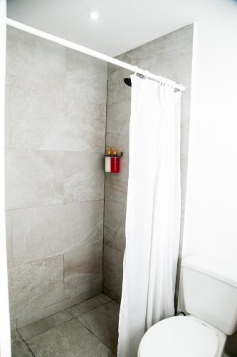 a bathroom with a shower curtain and a toilet at Booking 500 in Monterrey