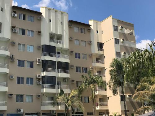an apartment building with palm trees in front of it at Paradise Temporada Cobertura 4 Quartos com Jacuzzi e Churrasqueira no Thermas Paradise - Rio Quente in Rio Quente