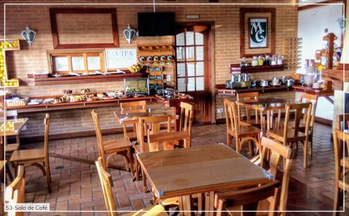 un ristorante con tavoli e sedie in legno in una stanza di Pousada Château' MG a Campos do Jordão