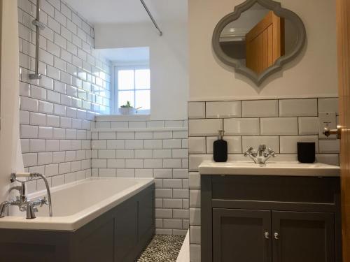 a bathroom with a tub and a sink and a mirror at Country Retreat in Highpeak Junction