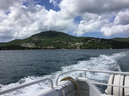 a boat on the water with a mountain in the background at DOUC IRMA in Les Trois-Îlets
