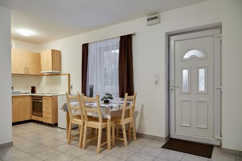 a kitchen with a table and chairs and a door at AqFel Airport Apartment in Vecsés