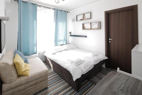 a small bedroom with a bed and a couch at Apartment Planinska Carolija in Kopaonik