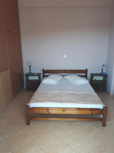 ein Schlafzimmer mit einem Bett mit zwei Nachttischen und zwei Tischen in der Unterkunft Mina Apartments in Zakharo